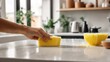 Kitchen cleaning. hand wipes the table with a yellow sponge