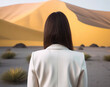 © ADDICTIVE STOCK CORE - Generative AI image of an unrecognizable back view of woman in a white blazer standing before a vast volcanic landscape
