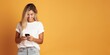 © Danko - Young blonde girl smiling confident using smartphone over isolated yellow background.