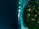 Fototapeta Sypialnia - View from above, stunning aerial view of a longtail boat sailing on a turquoise water. Phuket, Thailand.