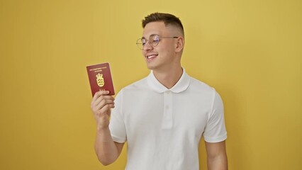 Wall Mural - Beaming hispanic man joyfully holds denmark's passport. his toothy smile and confident look spell success. posed on an isolated yellow background, he radiates happiness.