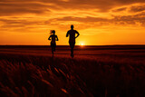 Fototapeta  - silhouette of man and woman jogging with sunset over the field, selective focus


