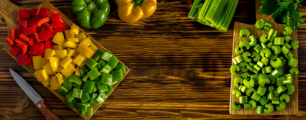 Wall Mural - Chopped fresh bell pepper and celery on the cutting board on the  wooden background. Top view. Copy space.