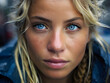 Portrait of a beautiful woman with blue eyes and blonde messy hair, looking at the camera.