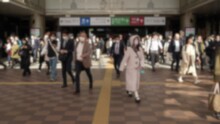 Slowmotion And Blurred Defocused View Of A Commuters Exiting The Metro Station In Japan, Rushing To Get To Their Workplaces. A Bustling Crowd Of People March Down The Busy Street