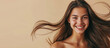 © SnowElf - Smiling young pretty woman with brunette brown long groomed hair isolated on pastel flat beige background with copy space. Perfect hair care products banner template, hair salon.