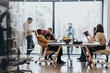 © qunica.com - Diverse employees collaborating in an innovative office. Discussing marketing strategies, analyzing finances, and solving problems together. Representing teamwork and cooperation.