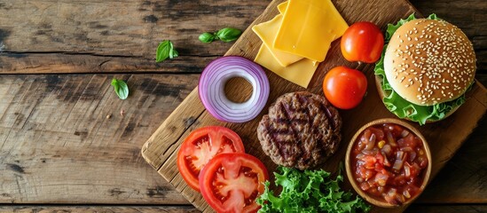 Poster - Beef burger ingredients on a wooden board with a place for text shot from above Grilled patty lettuce leaf tomato Cheddar cheese onion and a sesame bun. Copy space image