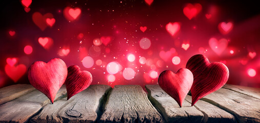 Wall Mural - valentines day - hearts on table in shiny abstract background with defocused lights