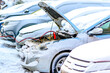 Charging automobile discharged battery by booster jumper cables at winter. Close-up. Problem starting a car in extreme freezing conditions.