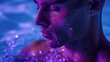 Man in water close-up. Face in splashes of water on ultra violet light.