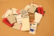 Leiden, Netherlands - December 6, 2023: Heart made of different clothing tags on kraft paper sheet, closeup