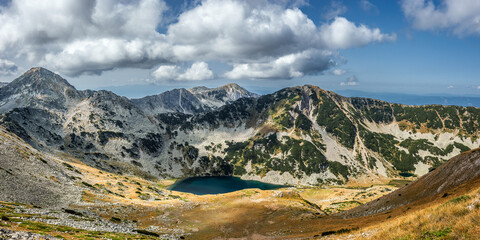 Wall Mural - Panoramic view of the Vlakhino lake from the pass between Vihren and Hvoinati peaks in autumn. Muratov peak on the left, Gredaro peak in center.