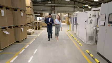 Canvas Print - Female warehouse manager talking with logistics employee in warehouse, planning transport of products, goods, talking shipping process.