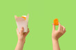 Leinwandbild Motiv Woman holding paper box with tasty nuggets on green background