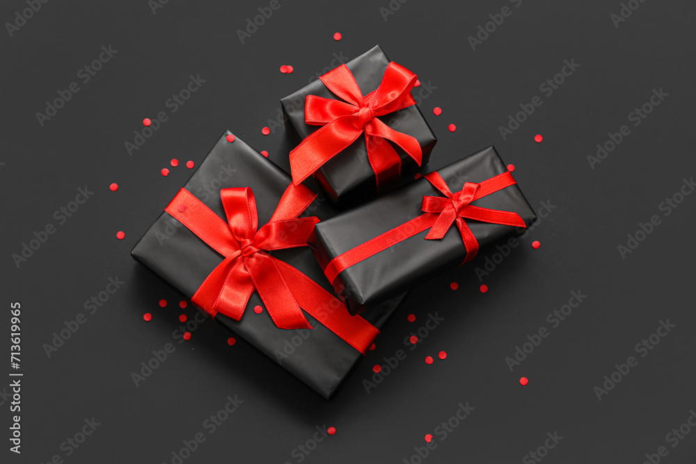 Gift boxes and confetti on dark background. Black Friday