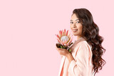 Fototapeta Tulipany - Young Asian woman with beautiful protea flower on pink background