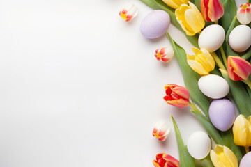 Easter background with spring flowers and colorful Easter eggs on white surface