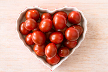 Wall Mural - Dark Red Grape Tomatoes in a Heart Shape Bowl