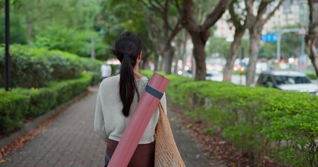 Wall Mural - Woman wear yoga mat and walk in the park