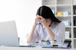 © Kainnika - Serious Asian businesswoman stressed with paperwork in the office.