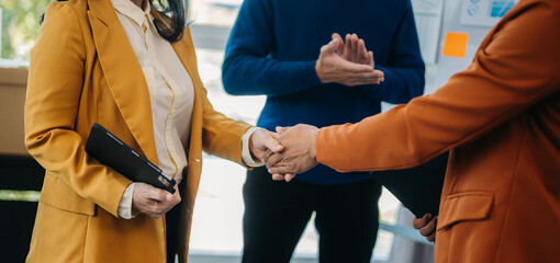 Young people professional colleagues are stretching arms showing team spirit focus on hands