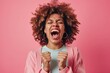 Ecstatic black woman yelling in victory, isolated pink backdrop