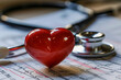 Stethoscope and red heart on the cardiogram background.