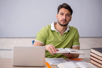 Wall Mural - Young male student sitting in front of whiteboard