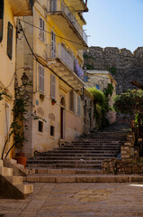 Romantic backstreet, side street or alleys in historic old town of Corfu Island, Greece with Mediterranean style architecture facades, a landmark sightseeing tourist spot in downtown Aegean Sea