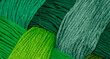 Piekne zielone tło z plecionych sznurków włóczki w rożnych cieniach zieleni, szycie z bliska