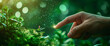 Human hand touching the green natural plants. Illuminated particle lights with hand's finger, green environment bokeh background