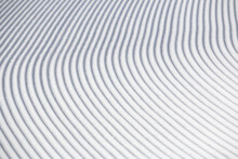 Curve Lines In Groomed Winter Snow Surface On White Ski Slope Abstract Texture Background