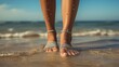 Close up of female legs walking on sandy beach at sunny day.
