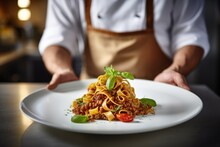 Italian Culinary Tradition: Savor The Culinary Artistry As A Chef Showcases A Mouthwatering Plate Of Tagliatelle Al Ragù Alla Bolognese, Epitomizing The Rich Essence Of Bolognese Cuisine.
