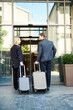 © Svitlana - Smiling young couple with suitcases entering hotel