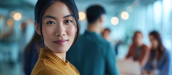 Young Asian business individuals dedicated to their work as they collaborate creatively at the office, gazing confidently at the camera.