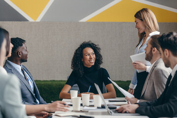 Canvas Print - Smiling group of business people discussing strategy during team meeting at the office together