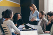 © gstockstudio - Happy group of business people discussing strategy during team meeting at the office together