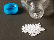 Plastic pellets and a plastic water bottle on a dark background
