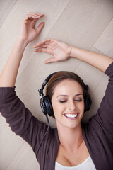 Wall Mural - Woman, headphones to listen to music and top view, happiness and relax at home with technology. Podcast, radio and audio streaming, peace and laying on apartment floor with smile, calm and album