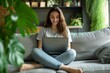 © Nuttakarn - Woman Relaxing with Laptop in Comfortable Home Setting