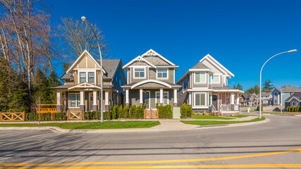 Wall Mural - Neighbourhood of luxury houses with street road, big trees and nice landscape in Vancouver, Canada. Blue sky.