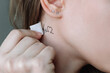 © Марина Демешко - A young woman applying a temporary mini tattoo in the form of a heart and a cardiogram on her neck