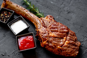 Wall Mural - Grilled Tomahawk steak on stone background 