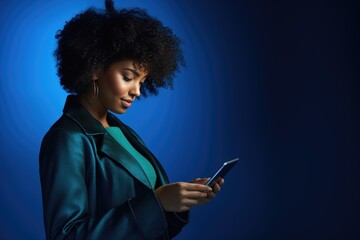 Happy black woman using digital tablet computer over blue studio background.
