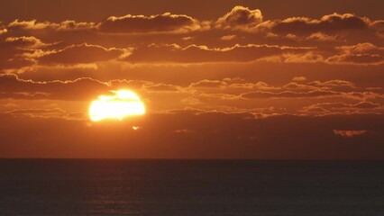 Wall Mural - beautiful evening sunset in the atlantic ocean at portugal coast. red big sun setting down in the oc
