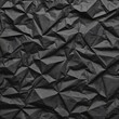 Black crumpled paper texture in low light background