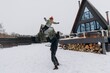 © Ananass - the father throws his daughter up high while playing against the background of a snowy house