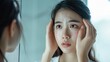 © buraratn - Dermatology, scratch asian young woman looking at mirror, expression worry and itch, itchy allergy or allergic sensitive reaction, red spot or rash on her face. Beauty care from skin problem treatment